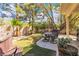 Backyard with a hot tub, patio seating, artificial grass, and mature landscaping for outdoor enjoyment at 1825 Derbyshire Dr, Las Vegas, NV 89117