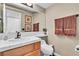 Well-lit bathroom features a vanity with a mirror, tiled countertop, and wall-mounted towel rack at 1825 Derbyshire Dr, Las Vegas, NV 89117