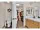 Well-lit bathroom with a toilet, vanity with sink, and an open closet with shelving and clothes rack at 1825 Derbyshire Dr, Las Vegas, NV 89117