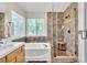 Spa-like bathroom with soaking tub, tiled shower, and large window for natural light at 1825 Derbyshire Dr, Las Vegas, NV 89117