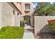 Close-up of gated walkway leading to the arched doorway with textured walls and mature landscaping at 1825 Derbyshire Dr, Las Vegas, NV 89117