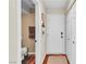 Functional hallway featuring a white front door, coat closet, and entrance to a cozy powder room at 1825 Derbyshire Dr, Las Vegas, NV 89117