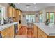 Well-lit kitchen featuring light wood cabinetry, tile countertops, and a breakfast nook with outdoor views at 1825 Derbyshire Dr, Las Vegas, NV 89117