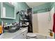 Green and turquoise bathroom featuring an above-counter glass sink, shower/tub combo, and modern fixtures at 2454 Paradise Village Way, Las Vegas, NV 89120