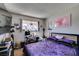 Bedroom featuring a patterned purple comforter, desk, shelving, and natural light from the window at 2454 Paradise Village Way, Las Vegas, NV 89120