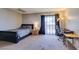 Bedroom featuring soft carpet, a queen bed, bedside table, a desk, and outside access via sliding glass doors at 2454 Paradise Village Way, Las Vegas, NV 89120