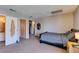 Spacious bedroom featuring soft carpet, a queen bed, bedside table, and access to the bathroom and hallway at 2454 Paradise Village Way, Las Vegas, NV 89120
