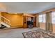 Carpeted living room with an entertainment center, stairs, and natural light from the window at 2454 Paradise Village Way, Las Vegas, NV 89120