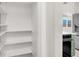 Bright pantry with white shelving next to a modern kitchen with stainless steel appliances at 2559 Winterwood Blvd, Las Vegas, NV 89142