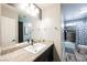 Updated bathroom with granite countertop, framed mirror, and tile shower/tub at 2860 Galena Peak Ln, Las Vegas, NV 89156