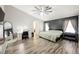 Spacious bedroom with wood-look floors, modern ceiling fan, and ensuite bath at 2860 Galena Peak Ln, Las Vegas, NV 89156