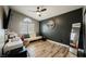 Contemporary bedroom with wood floors, a dark accent wall, and a ceiling fan at 2860 Galena Peak Ln, Las Vegas, NV 89156