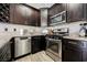 Fully equipped kitchen with stainless steel appliances, dark wood cabinetry and granite countertops at 2860 Galena Peak Ln, Las Vegas, NV 89156