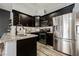 Well-appointed kitchen features dark wood cabinets, granite countertops, stainless steel appliances, and tile flooring at 2860 Galena Peak Ln, Las Vegas, NV 89156