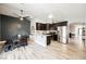 Modern kitchen with stainless steel appliances and dining area, dark wood cabinetry, and granite countertops at 2860 Galena Peak Ln, Las Vegas, NV 89156