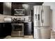 Stylish kitchen features stainless steel appliances, dark cabinetry, and granite countertops for a sleek look at 2860 Galena Peak Ln, Las Vegas, NV 89156