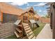 Wooden playground structure with a slide and climbing features in fenced yard at 2860 Galena Peak Ln, Las Vegas, NV 89156