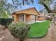 Serene backyard featuring a covered patio, green artificial grass, and convenient storage shed at 310 Sorrelwood St, Henderson, NV 89014