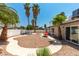 The backyard offers a built-in fire pit, patio space, and mature desert landscaping at 3143 La Mesa Dr, Henderson, NV 89014
