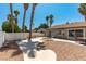 Home backyard featuring desert landscaping, a firepit, a concrete patio, and a white privacy fence at 3143 La Mesa Dr, Henderson, NV 89014