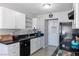 Well-lit kitchen features white cabinets, black appliances, and tile flooring at 3143 La Mesa Dr, Henderson, NV 89014