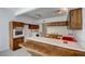 Charming kitchen featuring wood cabinetry, tile countertop, and a cozy breakfast bar area at 3368 Seneca Dr, Las Vegas, NV 89169