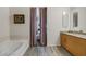 Bathroom featuring a soaking tub, vanity with granite counter, and neutral color scheme at 353 E Bonneville Ave # 555, Las Vegas, NV 89101