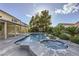 This backyard features a pool, in-ground spa, lush landscaping, a covered patio, and a view of the home at 386 Wiseton Ave, Las Vegas, NV 89183