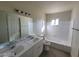 Well-lit bathroom featuring double sinks, a large mirror, and a combined bathtub and shower at 4321 El Conlon Ave, Las Vegas, NV 89102