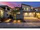 Contemporary home featuring a two-car garage, illuminated landscaping, and a modern design at 436 Crown Mesa Ave, Las Vegas, NV 89138