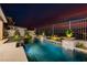 Inviting pool featuring a baja shelf, lush landscaping, and a captivating sunset backdrop at 436 Crown Mesa Ave, Las Vegas, NV 89138