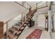Modern staircase with wood steps, glass railing, and view of the entry at 436 Crown Mesa Ave, Las Vegas, NV 89138