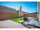 Private backyard with brick pavers, a small patch of artificial grass, and stylish patio furniture at 4634 Observed St, North Las Vegas, NV 89031