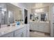 Bright bathroom featuring dual sinks with white cabinets and a large mirror at 4634 Observed St, North Las Vegas, NV 89031