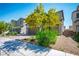 Two-story home with brown tiled roof, green shrubbery and tree with yellow flowers adorning the front yard at 4634 Observed St, North Las Vegas, NV 89031