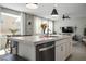 Kitchen island with stainless steel sink and dishwasher open to dining area and living area at 4634 Observed St, North Las Vegas, NV 89031