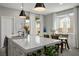 Bright kitchen with a large island, quartz countertop, and stainless steel sink is open to the dining area with large windows at 4634 Observed St, North Las Vegas, NV 89031