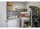 Laundry room with gray walls and a white washer and dryer set, as well as shelves at 4634 Observed St, North Las Vegas, NV 89031