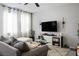 Comfortable living room features a plush sofa, area rug, and entertainment center with a large screen TV at 4634 Observed St, North Las Vegas, NV 89031