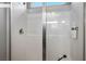Modern all-white tiled shower with glass enclosure and a sleek shower head at 4634 Observed St, North Las Vegas, NV 89031