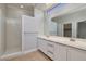 Bright bathroom featuring double sinks, a large mirror, and a step-in shower at 472 Via Stretto Ave, Henderson, NV 89011