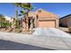 Charming single-story home with a tan brick exterior and a two-car garage at 472 Via Stretto Ave, Henderson, NV 89011