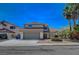 Charming two-story home featuring a tile roof, a spacious two-car garage, and mature palm trees in a well-maintained front yard at 4773 Sarazen Cir, Las Vegas, NV 89103