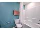 Well-lit bathroom showcases a white bathtub and toilet, complemented by a soothing blue wall at 6105 Aster Garden St # 160, North Las Vegas, NV 89081