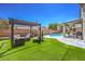 Backyard features outdoor seating, pergola, and pool, set on artificial turf at 6301 Citrine Ave, Las Vegas, NV 89130