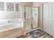 Bathroom featuring a soaking tub, glass-enclosed shower, and stylish tile accents at 6301 Citrine Ave, Las Vegas, NV 89130