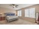 Cozy bedroom featuring a tufted headboard, two windows, neutral colors, and a ceiling fan at 6301 Citrine Ave, Las Vegas, NV 89130