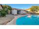 The beautiful backyard features a crystal blue swimming pool and lush landscaping at 6771 Shelter Ln, Las Vegas, NV 89103