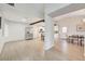 Open-concept living room with wood floors, wooden beam and stainless-steel appliances in kitchen area at 6771 Shelter Ln, Las Vegas, NV 89103