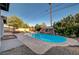 The backyard pool features a unique rock waterfall feature, stone tile surround, and lush landscaping at 6771 Shelter Ln, Las Vegas, NV 89103